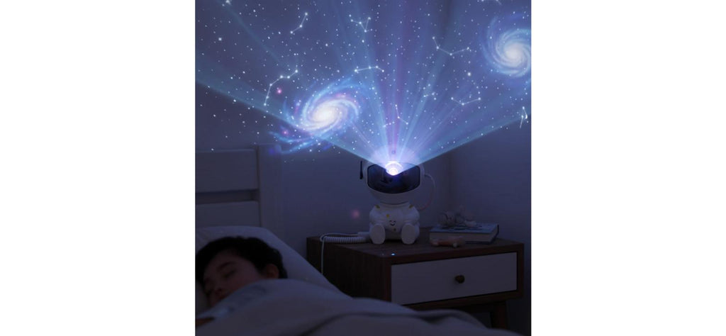 Astronaut Galaxy Star Projector Night Lamp – full galaxy and constellation display over a bed at night